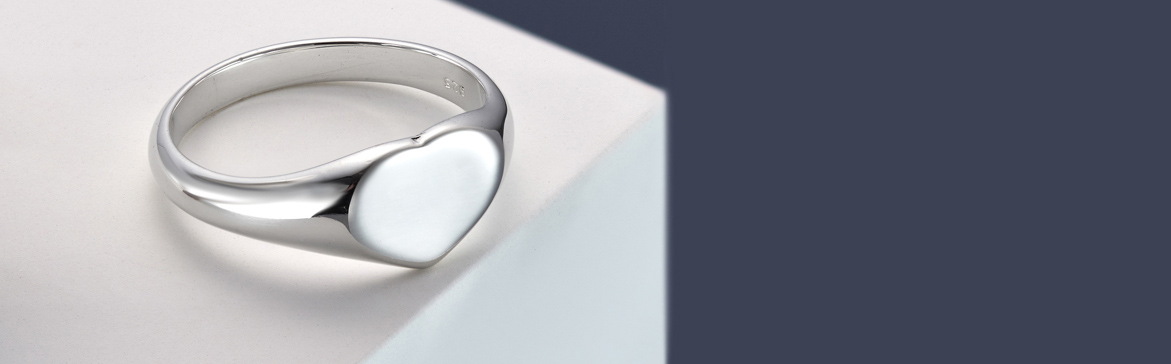 A Gorgeous Sterling Silver Heart Shaped Signet Ring on a blue and white background